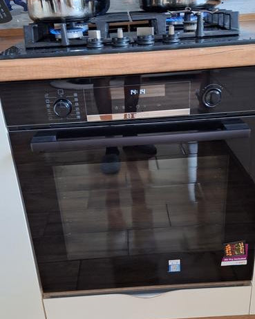 Horno pirolítico Bosch negro empotrado junto a anafe Samsung acero inoxidable