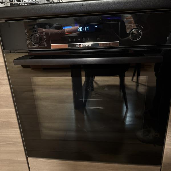 Horno pirolítico Bosch negro empotrado junto a anafe Samsung acero inoxidable