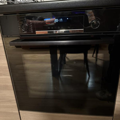 Horno pirolítico Bosch negro empotrado junto a anafe Samsung acero inoxidable